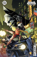 Comic book cover featuring Batman and Robin in an urban setting with neon lights.