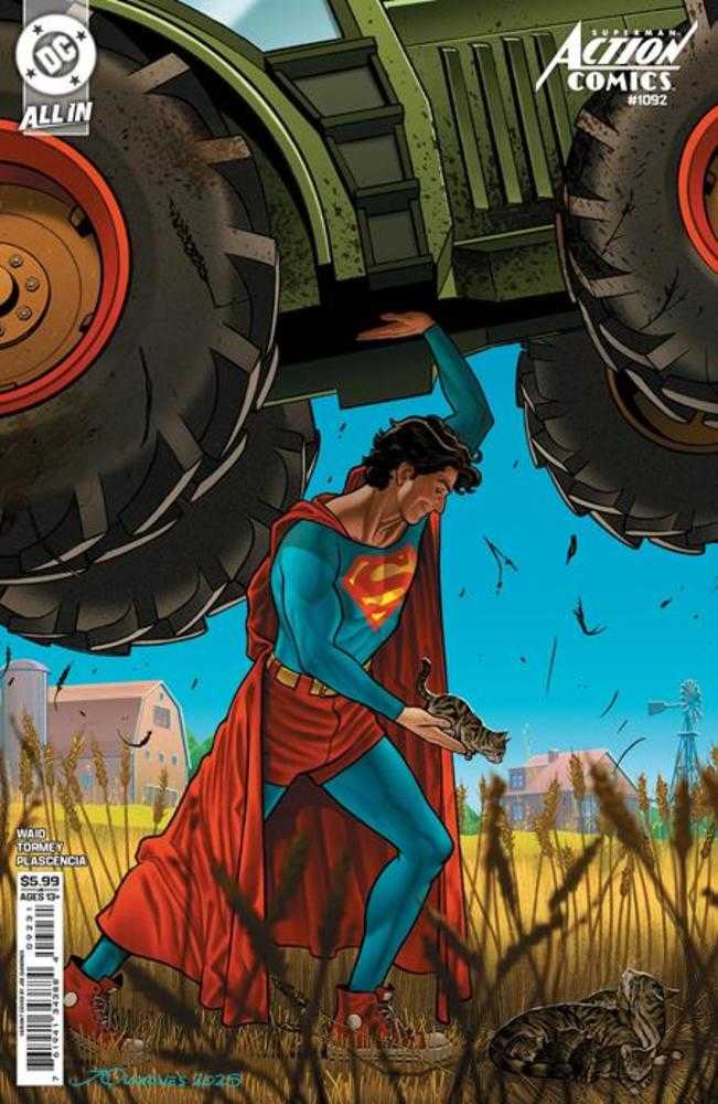 Superman holding a gun with large tires and a building in the background on a comic book cover.